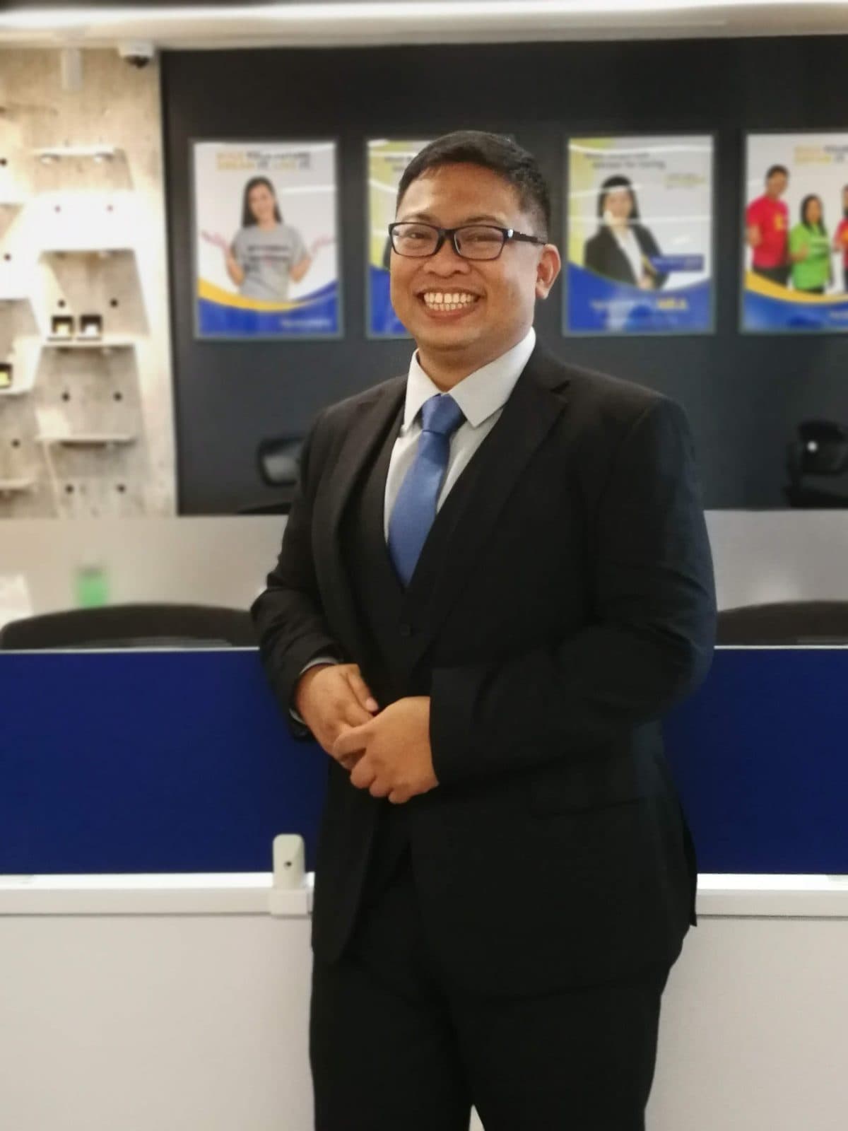 Aries Joseph Austria in a dark suit at the Sun Life Grepa office